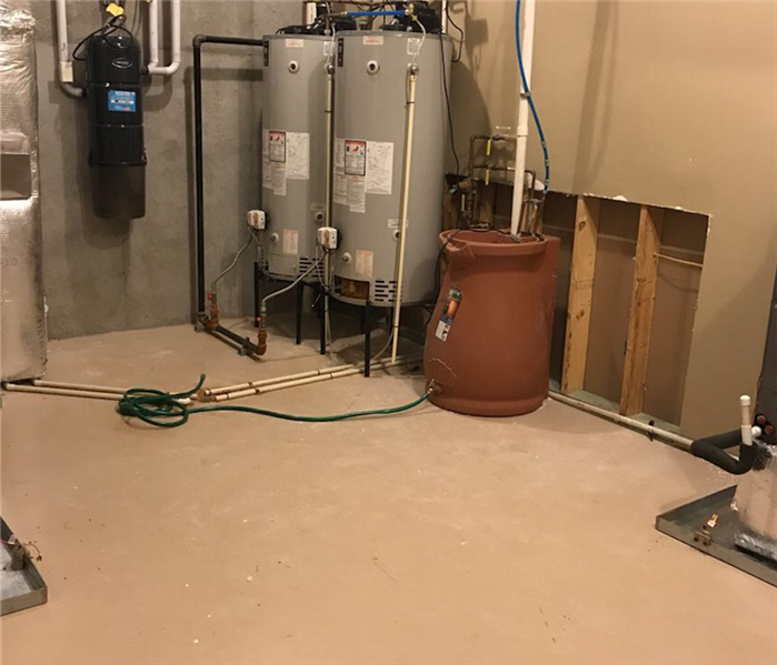 Dried And Restored Flooded Basement Around Hot Water Heaters In Corner.