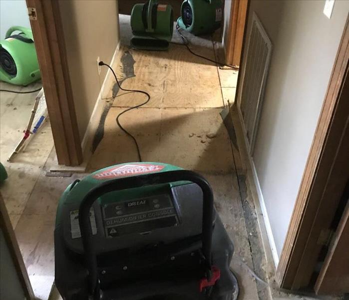 SERVPRO equipment sitting in hallway of a home that has faced water damage to their flooring.