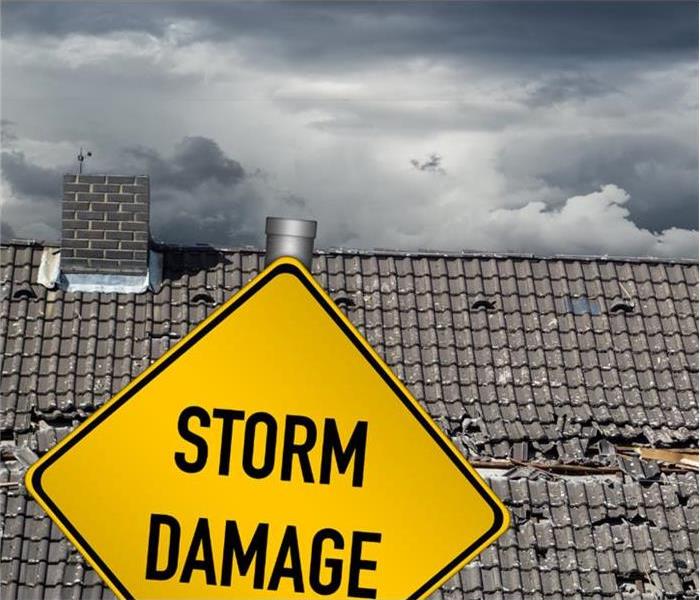 Storm Damaged Roof with Storm Damage Sign.